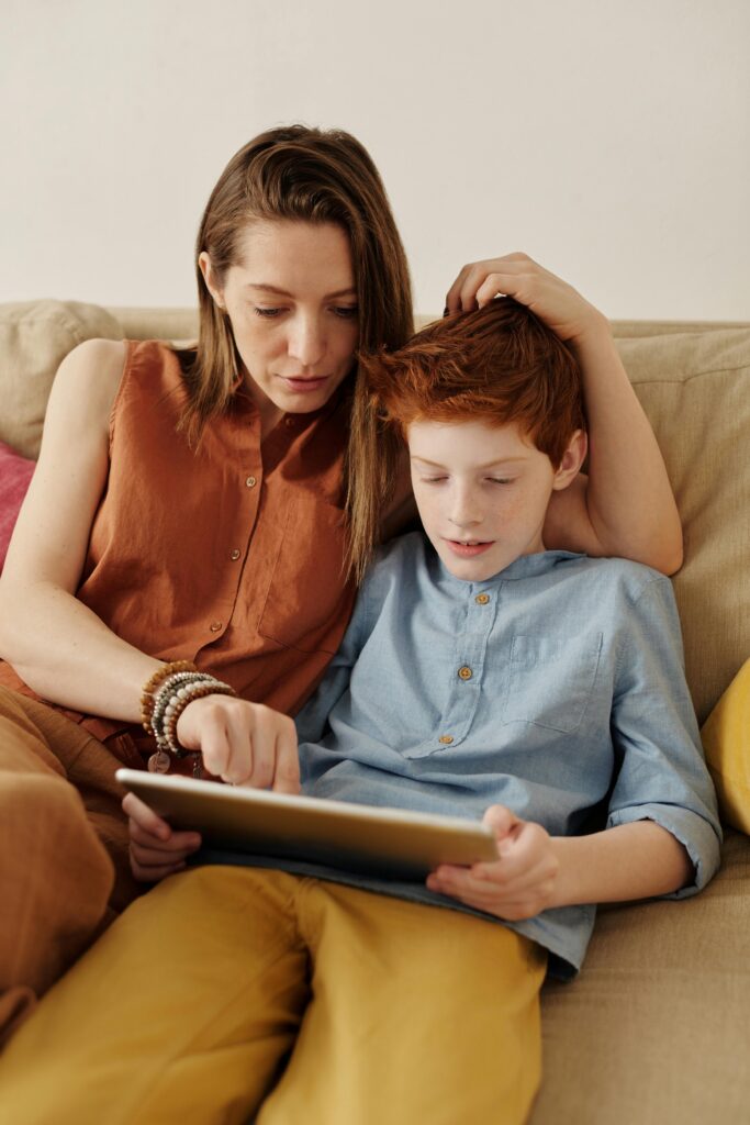 zipwp-image-4145348 A mother and son bonding as they use a tablet together indoors.