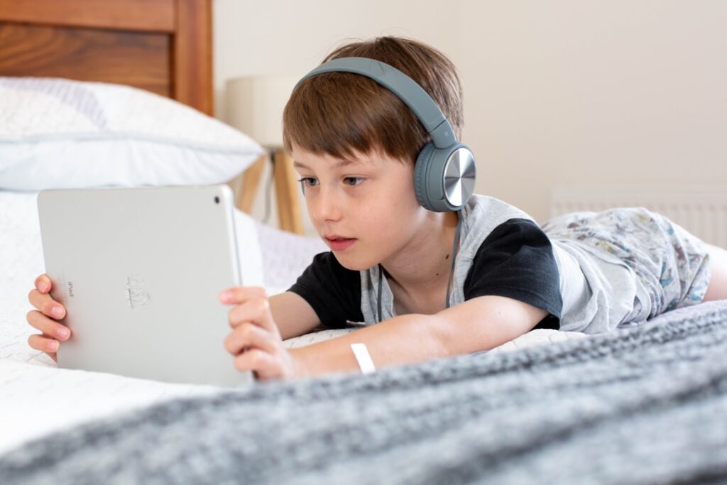 zipwp-image-dfqqkk2qqay Boy using iPad with headphones on